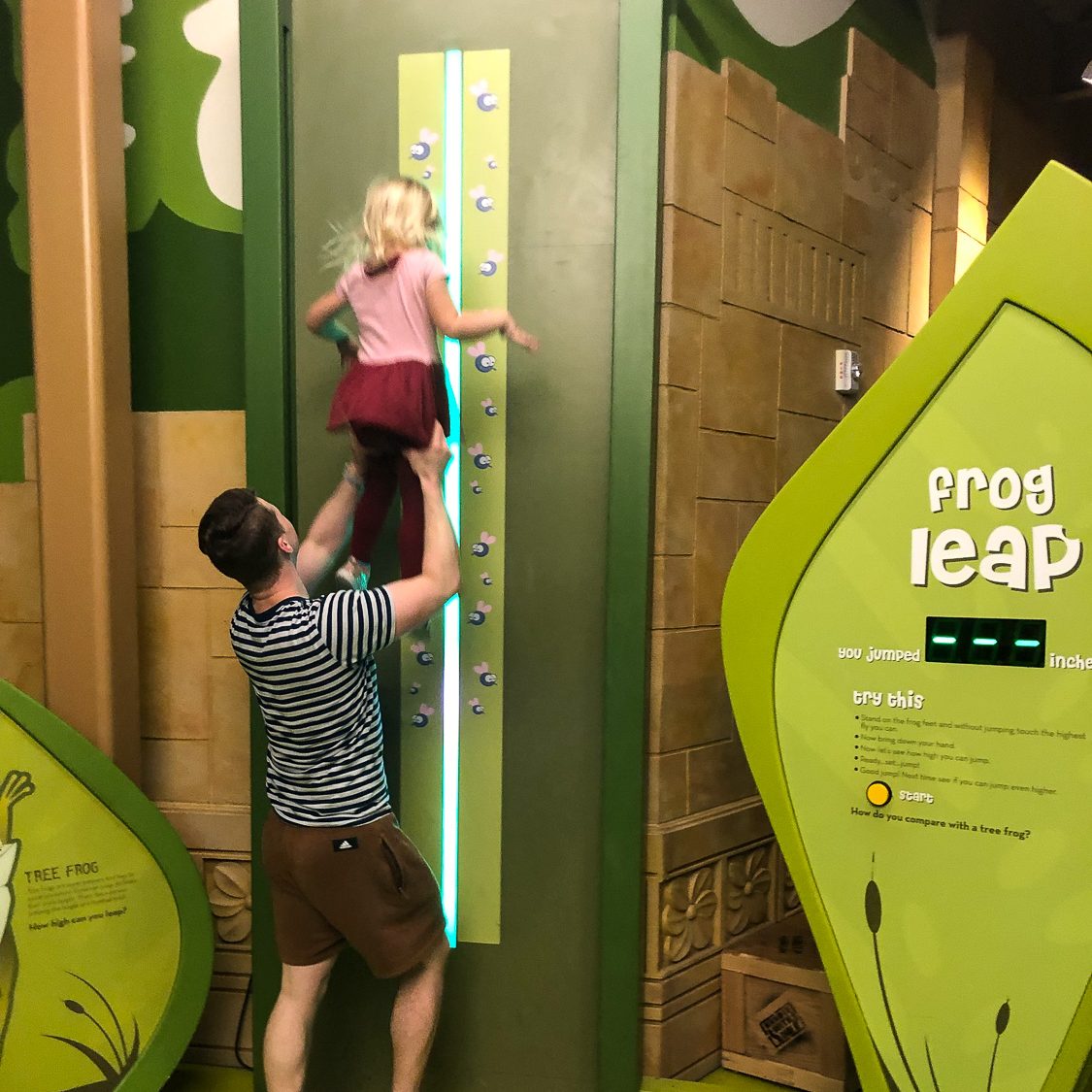 Oldest brother lifting up his little sister so she can participate in the who can jump the highest contest.